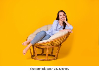 Portrait of her she nice attractive pretty lovely cheerful cheery girl sitting in cosy comfy wicker chair enjoying resting isolated bright vivid shine vibrant yellow color background