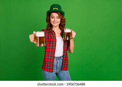 Portrait of her she nice attractive pretty cheerful cheery glad wavy-haired girl in checked shirt offering giving you beer isolated on bright vivid shine vibrant green color background
