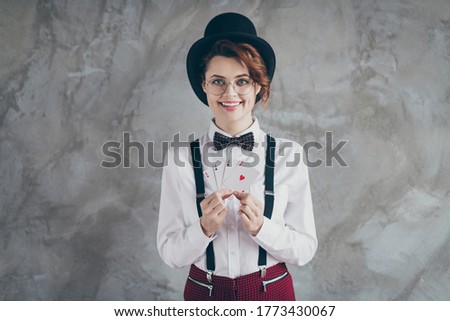 Portrait of her she nice attractive lovely cheerful cheery wavy-haired girl holding in hands paper cards ace blackjack leisure jackpot isolated on gray concrete industrial wall background