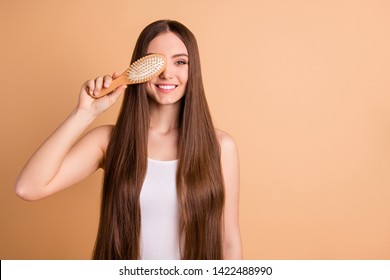 Portrait of her she nice-looking attractive lovely well-groomed cheerful cheery lady holding in hand comb closing face smooth soft silky hair effect keratin isolated on beige pastel background