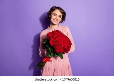 Portrait of her she nice-looking attractive lovely sweet winsome feminine cheerful cheery girl holding in hands red roses isolated on bright vivid shine vibrant lilac violet purple color background - Powered by Shutterstock