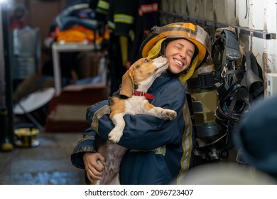 Portrait Heroic Fireman In Protective Suit Holds Saves Dog In His Arms,Firefighter In Fire Fighting Operation.