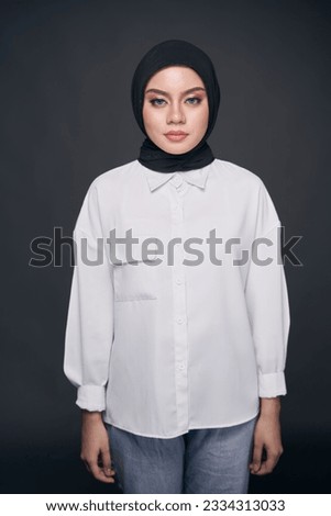 Portrait of hijab girl smiling. Pretty muslim girl. Beautiful asian muslimah woman model posing on dark background studio.