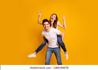 Portrait of his he her she two nice lovely charming attractive playful cheerful positive people showing double v-sign having fun isolated over vivid shine bright yellow background