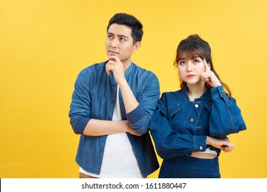 Portrait of his he her she nice attractive lovely curious bewildered couple thinking creating solution learning isolated over yellow color backgroun