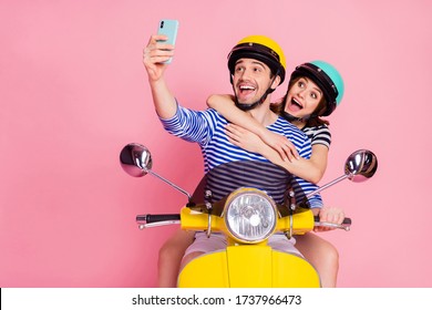 Portrait of his he her she nice attractive cheerful cheery childish funny glad couple driving moped taking making selfie having fun vacation day dream isolated on pink pastel color background
