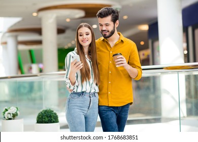 Portrait of his he her she nice attractive lovely pretty charming cheerful cheery couple embracing spending free time drinking latte using device blogging visiting commercial building indoors