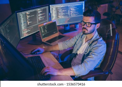 Portrait of his he nice attractive focused brunette guy creating script coding java html mysql database using languages software hard-working at dark room workplace station indoors