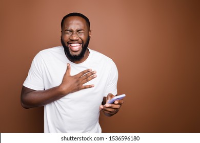 Portrait of his he nice attractive cheerful cheery bearded guy wearing white tshirt reading hilarious funny smm post blog story laughing isolated over dark brown pastel color background