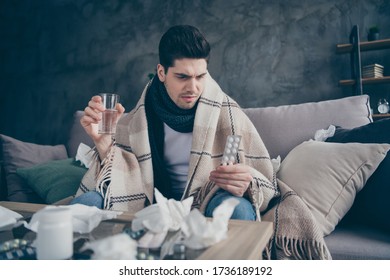 Portrait Of His He Nice Attractive Sick Guy Sitting On Divan Taking Drugs Healing Weakened Immunity Virus Disease At Modern Industrial Loft Concrete Brick Interior Style Living-room