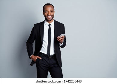 Portrait Of His He Nice Attractive Cheerful Cheery Chic Classy Luxury Imposing Guy Employee Banker Wearing Suit Holding In Hands Using Device Posing Isolated Over Grey Pastel Color Background