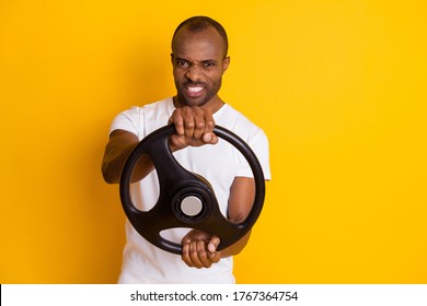 Portrait of his he nice attractive content mad angry addicted guy holding in hands steering wheel isolated over bright vivid shine vibrant yellow color background