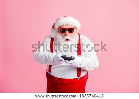Portrait of his he nice funny focused bearded fat guy Santa hipster using, gadget playing game station psp spending free time contest isolated pink pastel color background