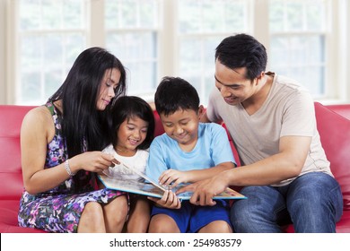 Portrait Of Hispanic Family Enjoy Read A Story Book Together At Home