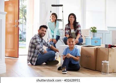 Portrait Of Hispanic Family Moving Into New Home