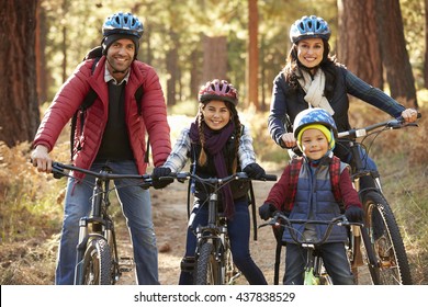 Portrait Of Hispanic Family On Bikes In A Forest