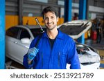 Portrait hispanic latin male mechanic repairs car in garage. Auto car mechanic professional working and checking car engine at garage. Car repair and maintenance