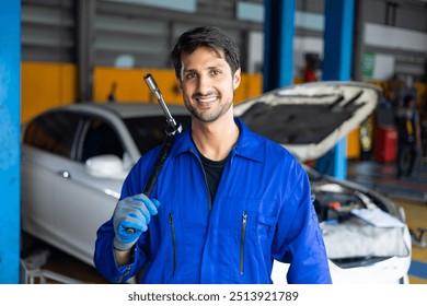 Portrait hispanic latin male mechanic repairs car in garage. Auto car mechanic professional working and checking car engine at garage. Car repair and maintenance - Powered by Shutterstock