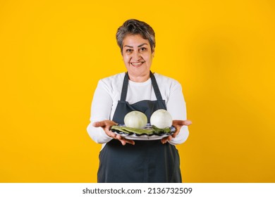 Portrait Of Hispanic Matured Woman Middle Aged Cooking And Holding Mexican Plate With Sauce Ingredients In Mexico Latin America
