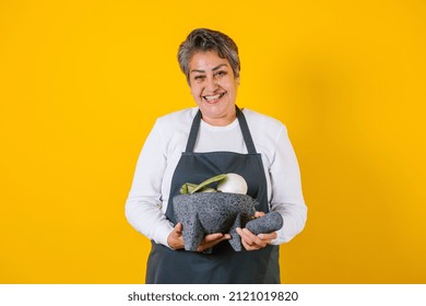 Portrait Of Hispanic Woman Middle Aged Cooking And Holding Mexican Mortar With Sauce Ingredients In Mexico Latin America
