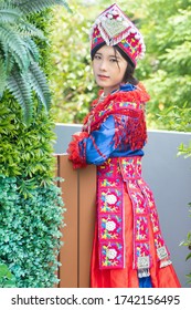 portrait of Hmong young woman looking up in tradition Hmong costume for young girl; Asian ethnic tribal people in traditional clothing culture of Hmong or Miao people in east and southeast Asia