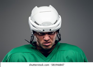 Portrait of hockey player isolated on grey background.