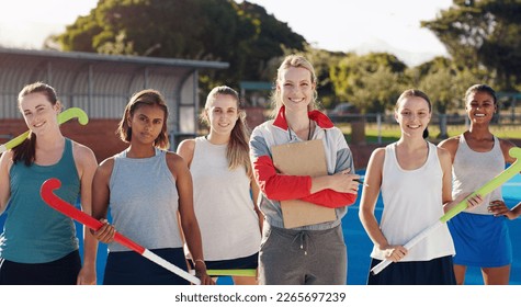 Portrait, hockey and a sports coach with her team standing outdoor together for training or a game. Teamwork, diversity and coaching with a female trainer outside with a girl group for sport - Powered by Shutterstock