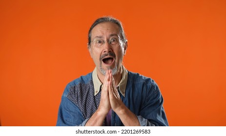 Portrait Of Hopeful, Praying Elderly Bearded Man 50s 60s Isolated On Solid Orange Background Studio