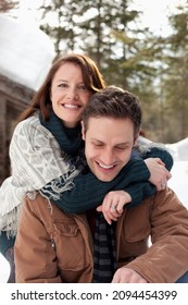 Portrait Of Hugging Couple Outside Snowy Cabin