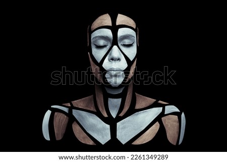 Portrait of a human with creative art makeup posing in the studio. Shape of silver gray and brown polygons on beautiful face, neck and shoulders. Parts of face isolated on black background.