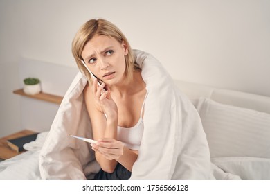 Portrait Of An Ill Young Blonde Female With A Sad Expression Making A Phone Call