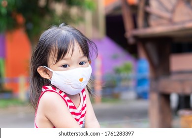 Portrait Image Of 2-3 Yeas Old Baby. Happy Asian Child Girl Smiling And Wearing Fabric Mask. She Playing​ At The Playground. Social​ Distance. Learning And Active Of Kids Concept.