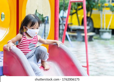 Portrait Image Of 2-3 Yeas Old Baby. Happy Asian Child Girl Smiling And Wearing Fabric Mask,​ She Playing With Slider Bar Toy At The Playground, Social​ Distance,​ Learning And Active Of Kids Concept.