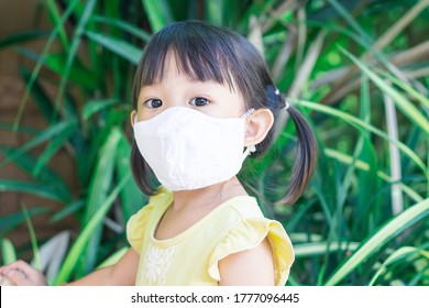 Portrait Image Of 2-3 Yeas Old Baby. Happy Asian Child Girl Smiling And Wearing Fabric Mask,​ She Playing With Slider Bar Toy At The Playground, Social​ Distance,​ Learning And Active Of Kids Concept.