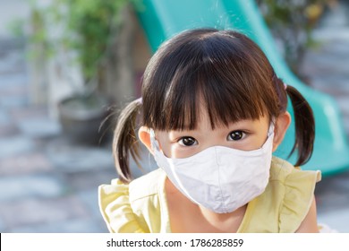 Portrait Image Of 2-3 Yeas Old Baby. Happy Asian Child Girl Smiling And Wearing Fabric Mask,​ She Playing With Slider Bar Toy At The Playground, Social​ Distance,​ Learning And Active Of Kids Concept.