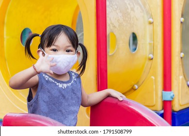 Portrait Image Of 2-3 Yeas Old Baby. Happy Asian Child Girl Smiling And Wearing Fabric Mask,​ She Playing With Slider Bar Toy At The Playground, Social​ Distance,​ Learning And Active Of Kids Concept.