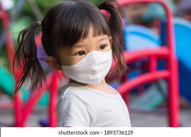 Portrait image of 2-3 yeas old baby. Happy Asian child girl smiling and wearing fabric mask.