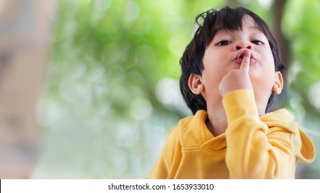 Portrait Image Of 3 Years Old Asian Boy Put His Finger To His Lip.Body Language Saying To Be Quiet Or Silent Please Or Don't Speak.