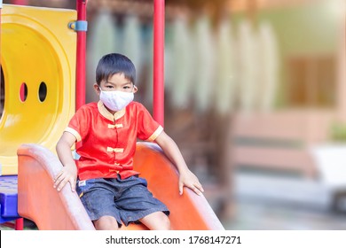 Portrait Image Of 6-7 Yeas Old Childhood, Happy Asian Child Boy Smiling And Wearing Fabric Mask,​ He Playing With Slider Bar Toy At The Playground, Social​ Distance,​ Learning And Active Of Kids.