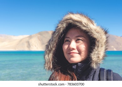 Portrait image of a beautiful Asian woman standing in front of Pangong lake , Ladakh India