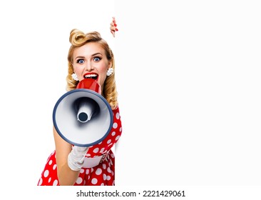 Portrait Image Of Beautiful Woman Holding Megaphone, Shout Advertising Something. Girl In Red Pin Up Style Dress With Mega Phone Loudspeaker Empty Banner With Copy Space. Isolated On White Background.