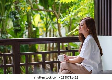 Portrait Image Of A Beautiful Young Asian Woman Drinking Coffee And Relaxing While Sitting On Balcony At Home