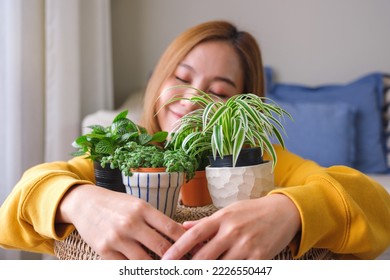 Portrait image of a beautiful young woman holding and hugging houseplants at home - Shutterstock ID 2226550447