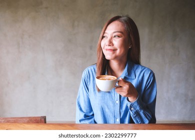 Portrait image of a beautiful young woman holding and drinking coffee - Powered by Shutterstock