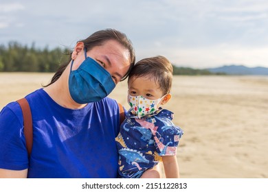 Portrait Image Of Happy Asian Mother And Kids With Wearing Medical Face Mask Enjoying Family Time On Beautiful Clean Beach