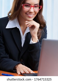 Portrait Image Of Smiling Businesswoman In Black Confident Style Suit And Red Eye Glasses, Working With Laptop Computer At Office. Success In Business, Job And Education, Zoom Conference Consulting.