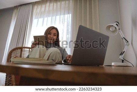 Portrait image of a young woman working or study on laptop computer at home