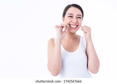 Portrait images of Asian young pretty woman, smiling, beautiful white and clean teeth, are using dental floss Clean teeth after eating For good dental health On white background to health care concept