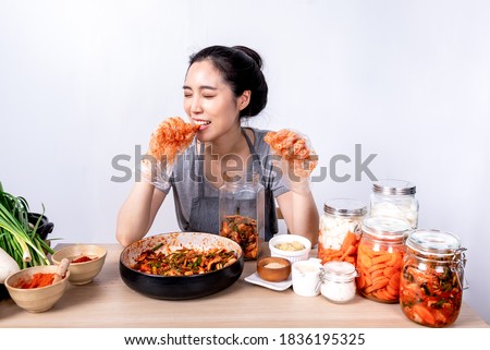 Portrait images of Korean attractive woman is eating Kimchi which she making,  Kimchi which is a fermentation food preservation of Korean people consisting of many fresh vegetables and fruits