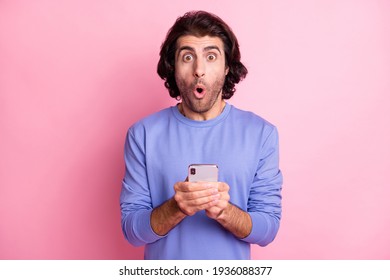 Portrait of impressed guy open mouth staring wrong message purple pullover isolated on pink color background